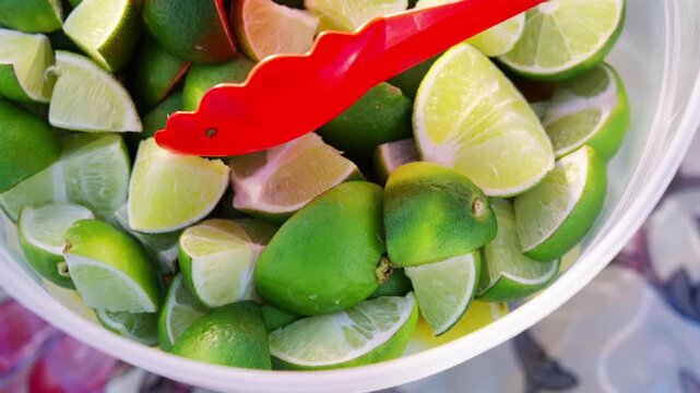 Close-up of fresh cut lime wedges prepared at a street taco stand, highlighting vibrant citrus ingredients used for authentic Mexican food and street food preparation.