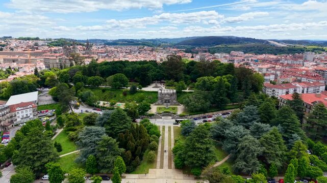 4K Drone shot of an empty, stationary 60-meter giant ferris wheel in La Alameda park, Santiago de Compostela. Cinematic daytime aerial view showing the massive metal structure contrasting with the his