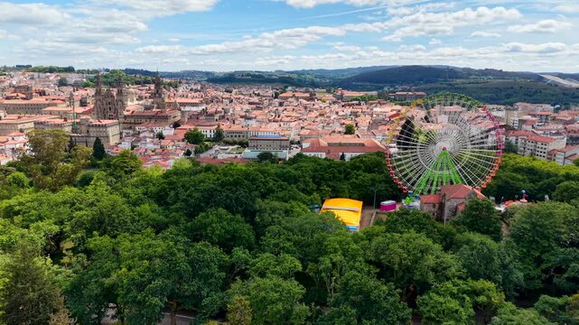 4K Drone shot of an empty, stationary 60-meter giant ferris wheel in La Alameda park, Santiago de Compostela. Cinematic daytime aerial view showing the massive metal structure contrasting with the his