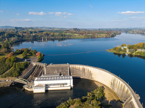 A curving concrete hydroelectric dam on Lake Karapiro in the Waikato region of New Zealand. Aerial view