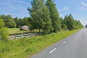 Rural scene along a road with Sepa Suurkivi (Sepa Great Stone) boulder in background in sunny summer weather, Saaremaa, Estonia, Europe. © Raimo Bergroth