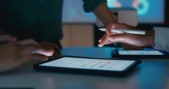 Closeup group Asian businesspeople work together discuss plan idea with data profit sale statistics in business meeting in office night. Financial generation z team brainstorm on e-Commerce project.