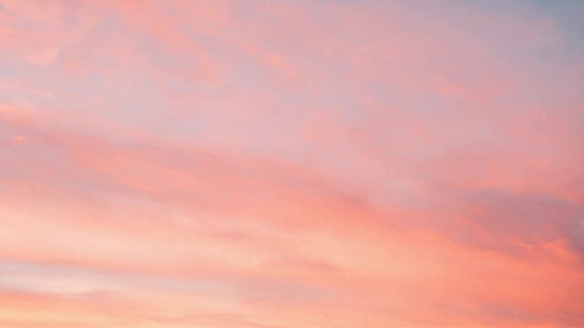Gentle peach and blue pastel sky with wispy clouds at calm summer sunset
