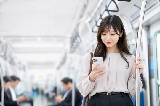 電車内でスマートフォンを見る笑顔の日本人女性 Generative AI