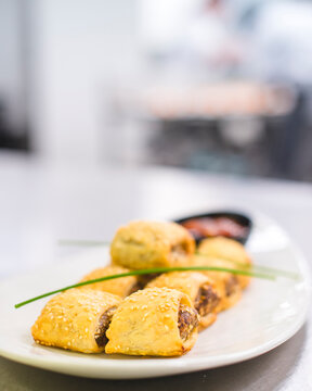 Sausage Rolls canap&eacute;s on white platter, a popular Australian party food, selective focus space for copy