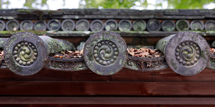 Detail of decorative roof end tiles with tomoe spiral pattern on Japanese temple, Kyoto, Japan