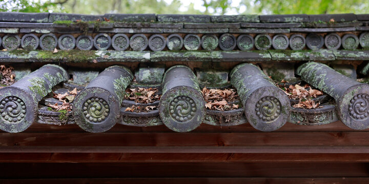 Detail of decorative roof end tiles with tomoe spiral pattern on Japanese temple, Kyoto, Japan