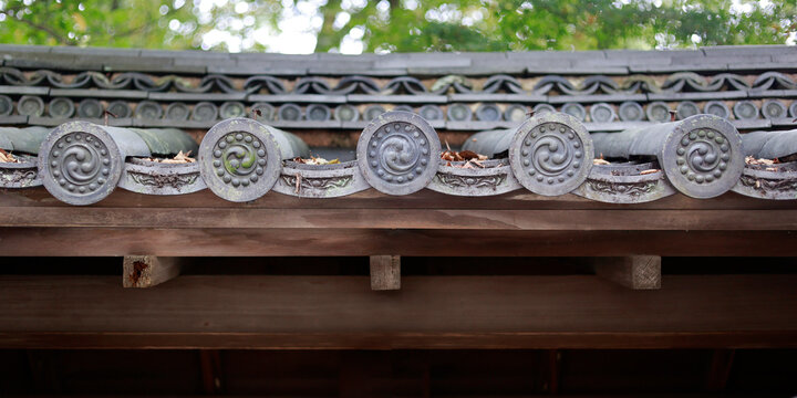 Detail of decorative roof end tiles with tomoe spiral pattern on Japanese temple, Kyoto, Japan