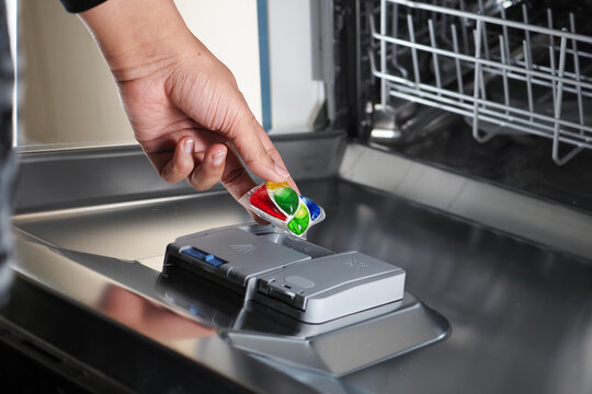 Filling dishwasher with detergent pod for cleaning dishes