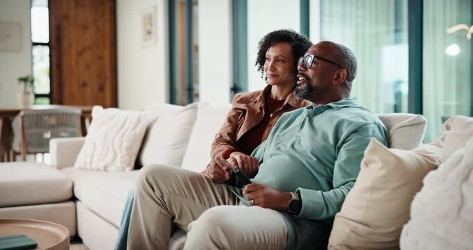 Watching tv, home and couple with remote on sofa, entertainment or relax with partner in living room. Happy, mature man and bonding with African woman in lounge, streaming movie and change channel