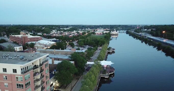 Aerial drone video moving down with the river reflecting in downtown Elgin, Illinois.