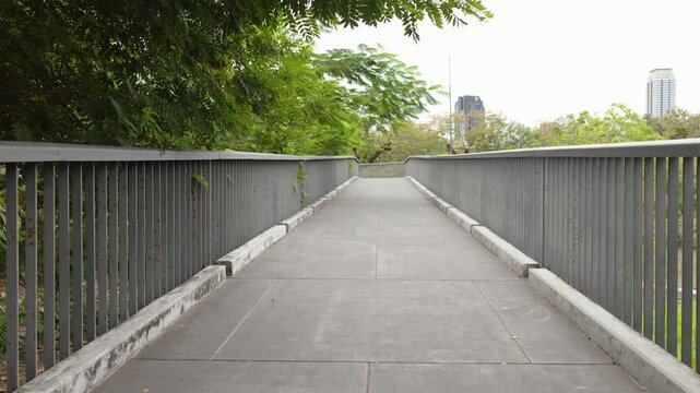 Elevated Walkway Through Lush Green Trees in Benchakitti Park Bangkok