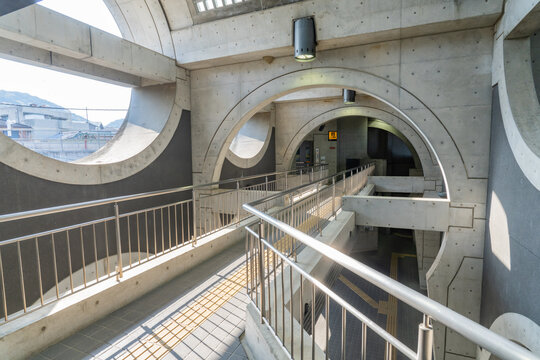 Uji Station, Kyoto, Japan - April 08, 2026 - Modern brutalist concrete architecture interior of Uji Station in Kyoto, Japan, featuring geometric arches, circular cutouts, skylights, escalators