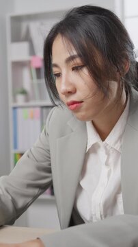 Vertical Screen : Young Asian businesswoman with laptop overworked tired burnout syndrome at office. Exhausted lady with sleeply eye at workplace, Girl not enjoy unhappy with work, Work mental health.