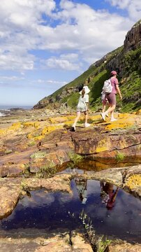 Mom and twin daughters hike Robberg nature reserve circular trail. Vertical