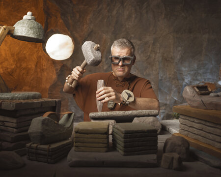 Frustrated office worker caveman hand carving inscriptions on a stone tablet