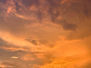 Fototapeta premium Cinematic orange sunset clouds with dramatic pastel sky and soft texture, captured in wide-angle focus. Perfect for luxury branding, wellness ads, travel banners and aesthetic wallpapers.