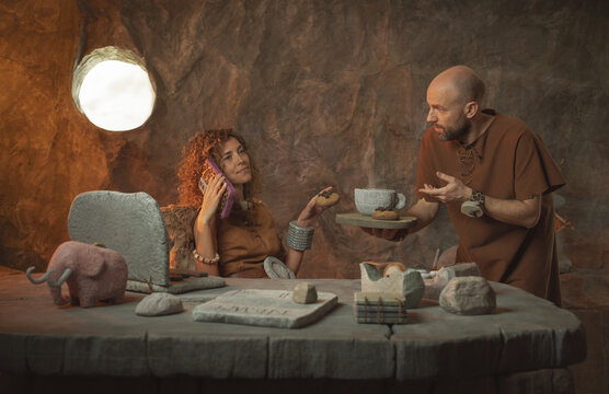 Business in the stone age: confident female boss and submissive male assistant