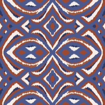 Seamless ethnic ikat pattern featuring bold slate blue and terracotta geometric motifs. Symmetrical tribal design ideal for bohemian fabric prints, wallpaper, and rustic background decor.