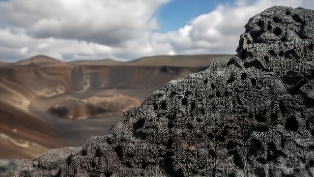 scoria. Porous black volcanic scoria at a crater's edge, textured surface. travel magazines, destination branding, designed for outdoor magazines and nature guides, inspires travel planning.