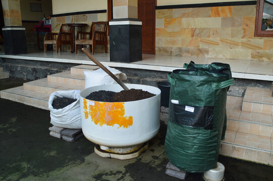 Quarter right high angle terrace composition showing organic soil media mixing materials with charcoal husk, compost bags, and gardening bucket tools.