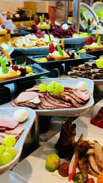 Luxury buffet with smoked salmon, cured beef, basturma, and assorted cold appetizers at a 5-star hotel restaurant. Premium resort dining selection on a sunny terrace in Sharm El Sheikh, Egypt.