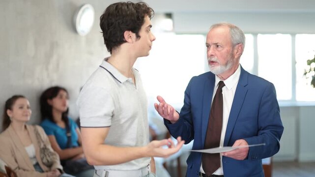 Elderly man communicates with a guy, they discuss documents and an interview. Male student gets a job in a company. High quality 4k footage