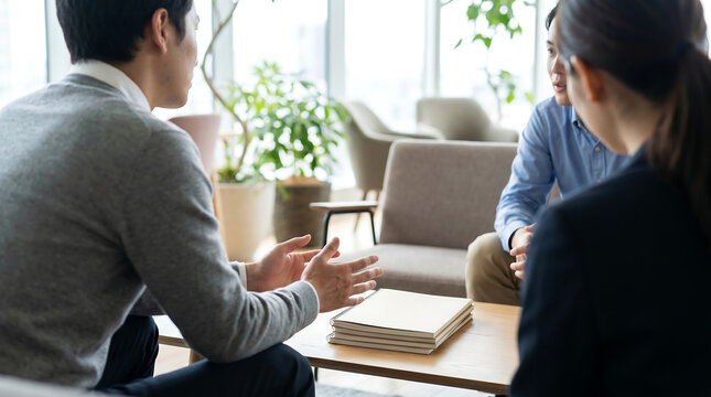 Three anonymous coworkers rebuilding trust in a quiet office lounge through calm listening open hands and supportive workplace communication
