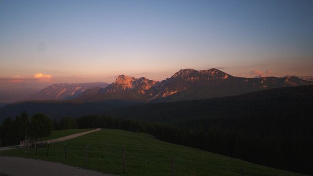 Dramatic sunset time-lapse from Teisenberg summit featuring red alpenglow over the Salzburg Alps.