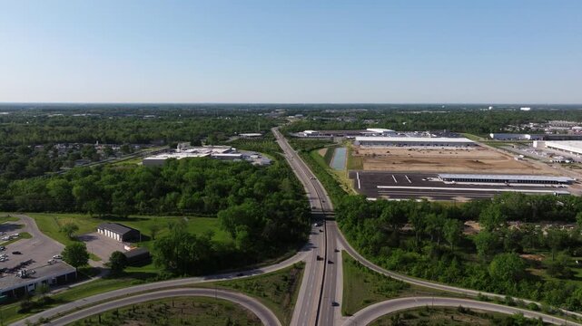 Aerial establishing pullback of interstate interchange near industrial district, drone