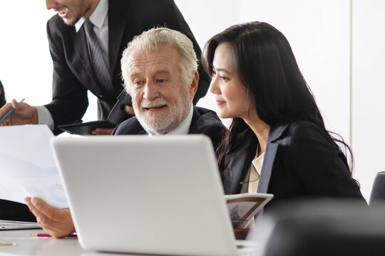 Marketing team consulting sales plan with supervisor senior manager in conference room before presenting to client.