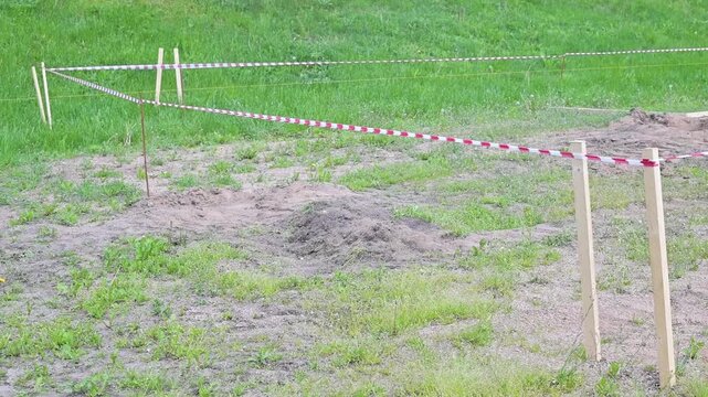 Straight survey lines are set up across an open field, demarcating the area for a construction project