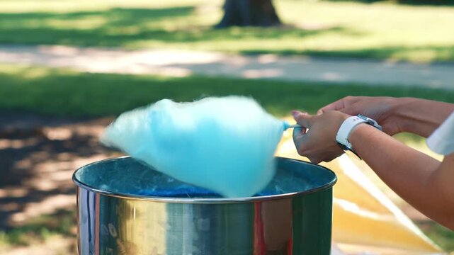 Blue Cotton Candy Spinning Above Sweet Treat Machine showing the creation process of a popular festive dessert during outdoor recreation and entertainment activities