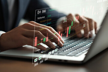 Fototapeta premium Hands Typing on Laptop with Digital Stock Market Graph and Trading Data Displayed on Screen for Financial Analysis and Investment Strategies