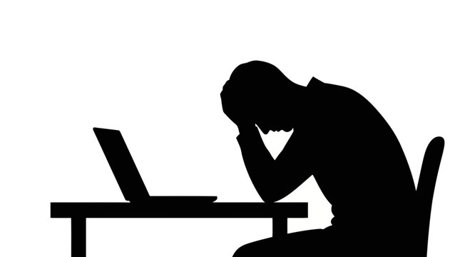 Silhouette of a person sitting at a desk with head in hands, expressing frustration or despair in a work environment