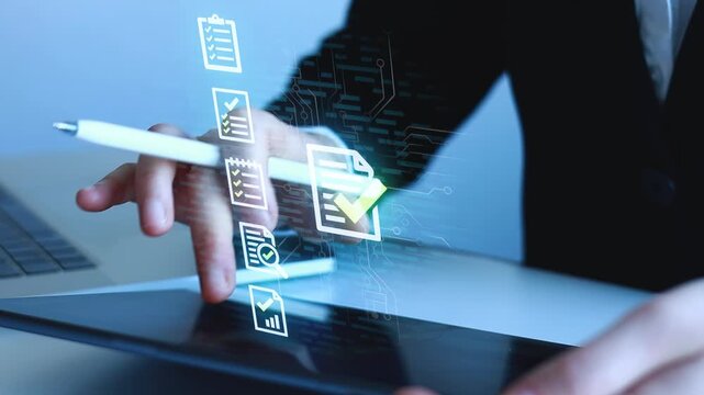 Person works on digital document with a tablet and computer in an office setting during daytime while using a stylus.
