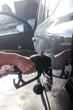 Hand of a woman at a fuel bowser filling a car with diesel