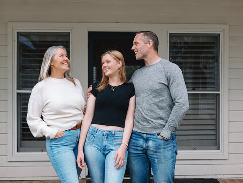Happy family standing in the porch of their new home