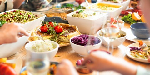 A vibrant buffet table with diverse dishes and people serving themselves.