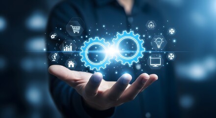 Fototapeta premium Hand holding glowing digital gears with business icons representing innovation technology and interconnected systems