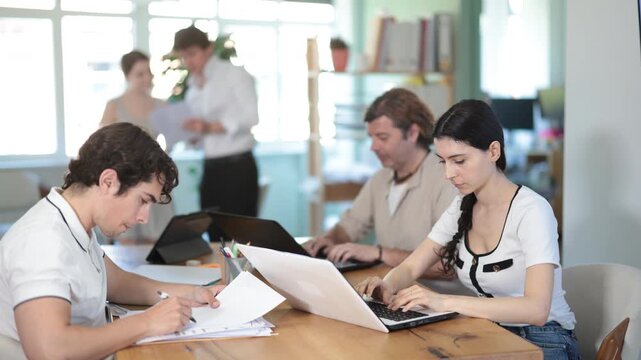 Several managers work together in a modern office. A well-coordinated management team