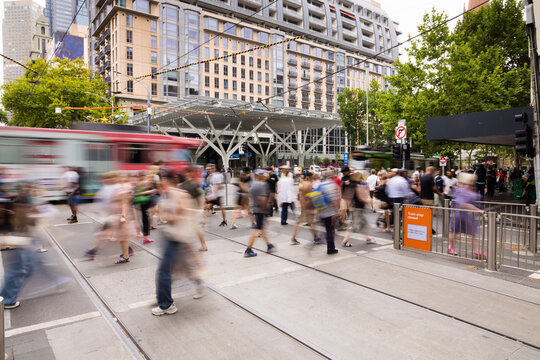 Busy urban street with people and reed tram in motion blur