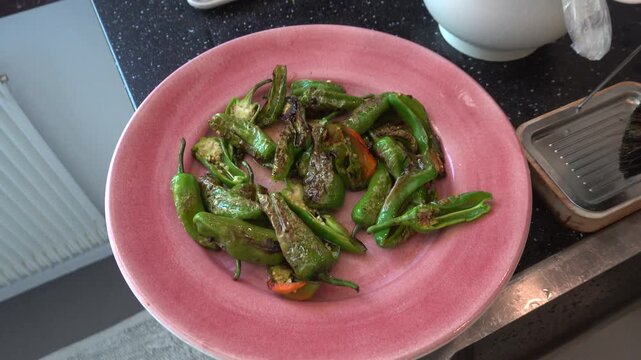 Stockholm, Sweden Fried green peppers with garlic and oil, salt and pepper.