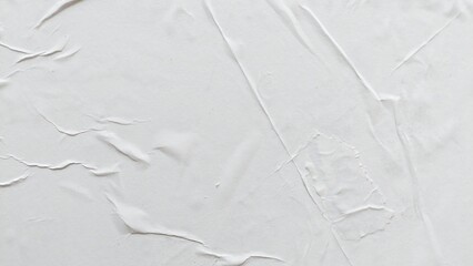 Blank white creased paper background with soft crushed poster texture effect. Wrinkled abstract white paper surface with natural wavy folds and old crumpled texture backdrop. © Firman