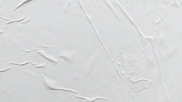 Blank white creased paper background with soft crushed poster texture effect. Wrinkled abstract white paper surface with natural wavy folds and old crumpled texture backdrop.