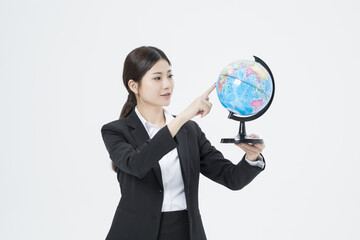 Fototapeta premium Businesswoman Pointing at Globe for Global Strategy