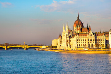 Obraz premium Vibrant color view of hungarian Parliament building, Danube and bridge at sunset, Hungary