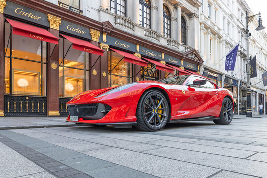 Red Ferrari sports car parked on a luxury city street. London, UK, 28 August 2023