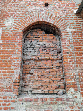 Detail of bricked up arched window in ancient orthodox church in Yelets with weathered stone facade