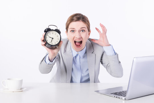 Stressed Businesswoman Holding Alarm Clock at Desk